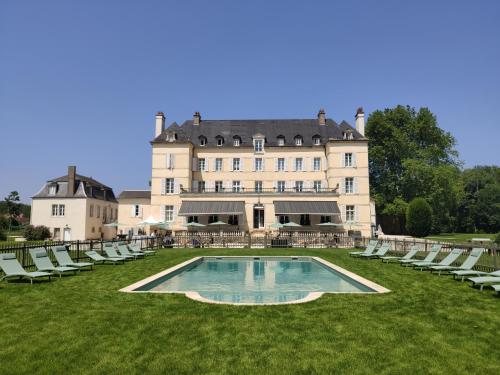 ein großes Gebäude mit Stühlen und einem Pool davor in der Unterkunft Domaine de Saulon in Saulon-la-Rue