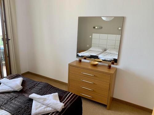 a bedroom with a bed and a mirror on a dresser at View Apartments in Sozopol