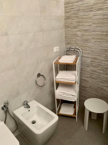 a bathroom with a sink and a shelf with towels at InterMezzo - located in the center of Salento equidistant from the 2 seas in Scorrano