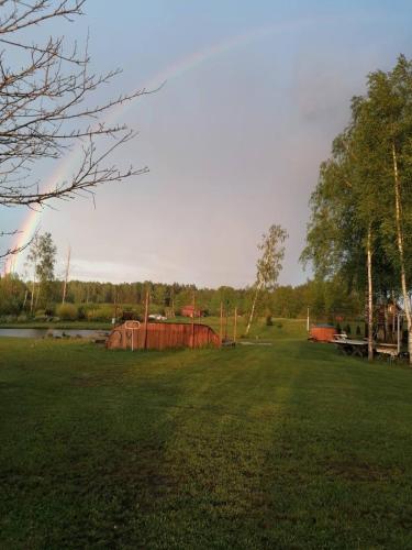 a large grass field with a rainbow in the sky at Residence R&R in Karvys