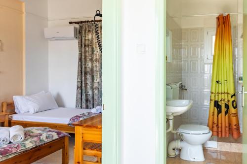 Habitación con cama, aseo y lavabo. en Stafylos Rooms, en Stafylos