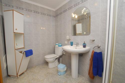 a bathroom with a sink and a toilet and a mirror at El Lago del Mar in Arrieta