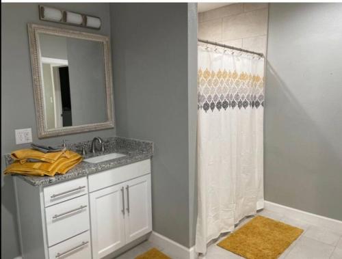 a bathroom with a sink and a shower with a mirror at Comfortable Suite with private entrance & private bathroom in El Paso