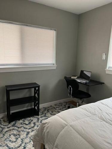 a bedroom with a bed and a desk with a laptop at Comfortable Suite with private entrance & private bathroom in El Paso