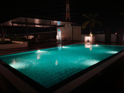 a swimming pool lit up at night at Preferred30 3R2B 7pax Meritus Perai in Perai