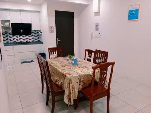 a dining room with a table and chairs and a television at Preferred30 3R2B 7pax Meritus Perai in Perai