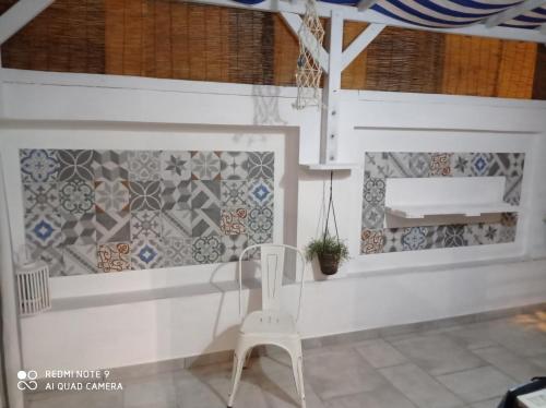 una mesa y una silla en una habitación con azulejos en Casa vacanze Tre stelle, en Termoli