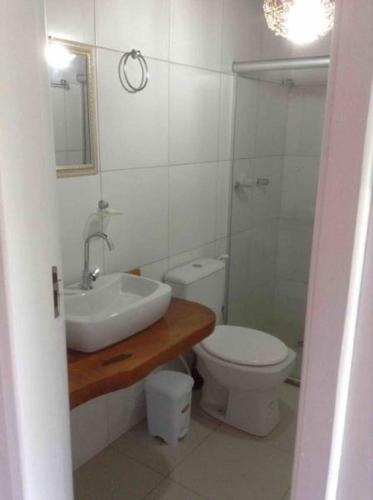 a bathroom with a sink and a toilet and a mirror at Flat Casagrande in Morro de São Paulo