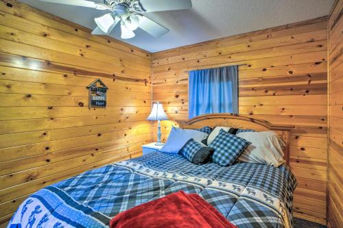 een slaapkamer met een bed met houten wanden en een plafond bij Quaint Lake Jefferson Cabin with Deck and Gas Grill! 
