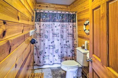 a bathroom with a toilet and a shower curtain at Quaint Lake Jefferson Cabin with Deck and Gas Grill! 