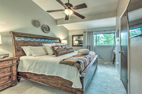 een slaapkamer met een groot bed met een plafondventilator bij Rustic Ruidoso Retreat Near Shops and Mountains! in Ruidoso
