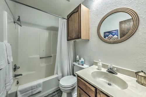 een badkamer met een wastafel, een toilet en een spiegel bij Rustic Ruidoso Retreat Near Shops and Mountains! in Ruidoso