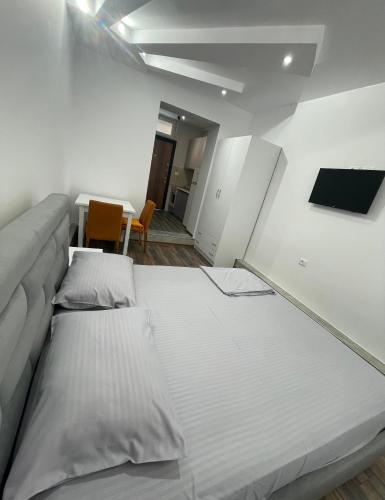 two large beds in a room with a couch at Apartament The City Block in Pogradec