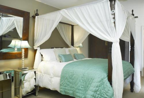 a bedroom with a bed with a canopy at Windfalls Boutique Hotel in Crawley