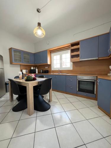 a kitchen with blue cabinets and a table in it at JET, luxury appartment 20m from the beach in Kinion