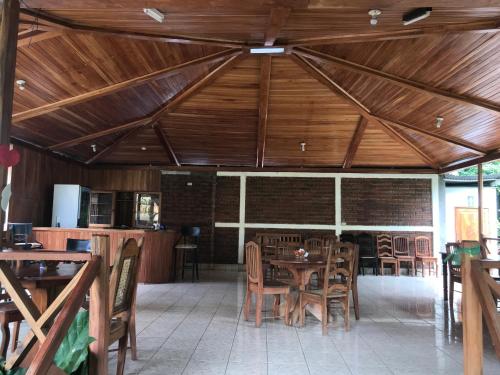 comedor con mesas y sillas de madera en Hotel Ometepetl en Moyogalpa