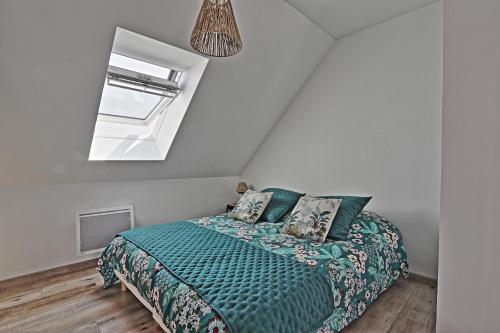 1 dormitorio con 1 cama con edredón verde y ventana en LES RIDAINS, en Sangatte
