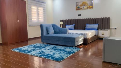a bedroom with a bed and a blue chair at Les HOTELS TALHAYA, NOUAKCHOTT in Nouakchott