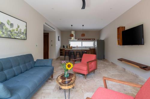 a living room with a blue couch and a table at Valhalla Residences by Biwa in Tulum