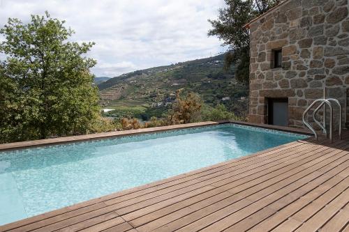 a swimming pool on a wooden deck next to a building at Quinta de São Pedro in Resende