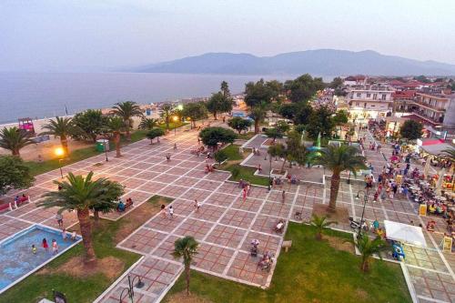 Un gruppo di persone che si aggirano intorno a una piazza vicino all'acqua di villa panorama a Asprovalta