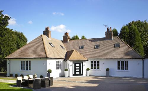 a white house with chairs in front of it at Windfalls Boutique Hotel in Crawley