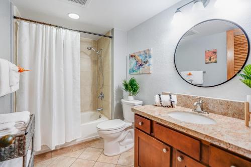 ein Badezimmer mit Waschbecken, Toilette und Spiegel in der Unterkunft Makahuena 4105 Poipu Ocean Breeze in Kipu