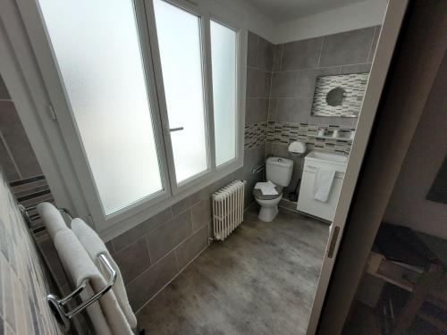a bathroom with a toilet and a window at Le Cérétan Hôtel in Céret