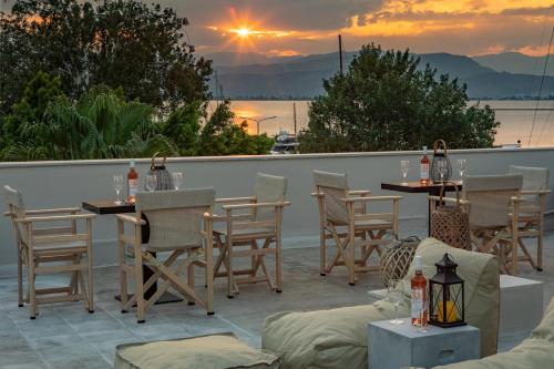 a patio with tables and chairs with a sunset in the background at Eudokia Pension in Nafplio