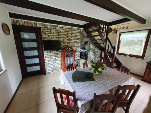 a dining room with a table and chairs and a staircase at Domki Niesiołowice in Niesiołowice