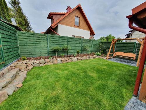 a garden with a fence and a lawn at Domki Niesiołowice in Niesiołowice
