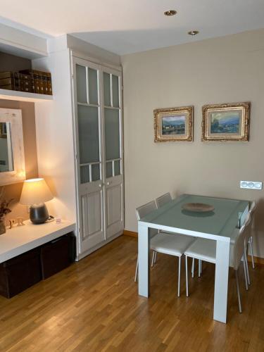 une salle à manger avec une table et des chaises blanches dans l'établissement Petit Rosselló, à Barcelone