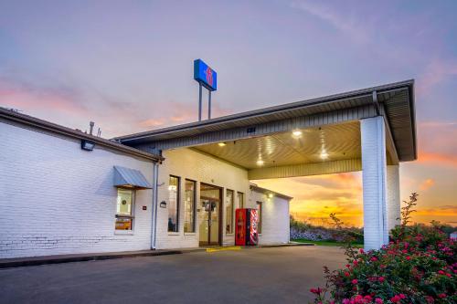 a mobil gas station with a sunset in the background at Motel 6-Grand Rivers, KY in Grand Rivers