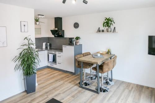 a kitchen with a wooden table in a room at Wohlfühlwohnung im Zentrum mit 24-7 Self Check-In, WLAN & Smart TV in Kiel
