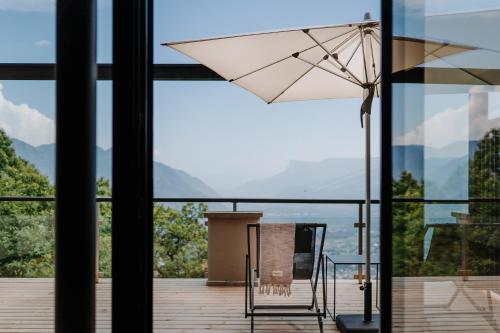 un ombrellone bianco seduto sopra un balcone di farnhaus a Tirolo