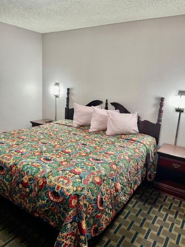 ビッグ・スプリングにあるBradbury Innのベッドルーム1室(カラフルな毛布付きのベッド1台付)