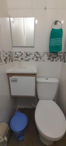 a bathroom with a toilet and a sink and a mirror at temporada praia do forte cabo frio in Cabo Frio