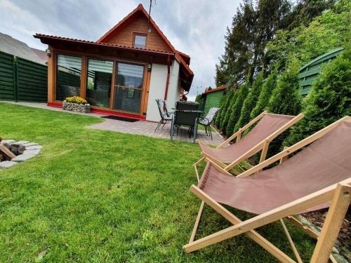 a couple of lawn chairs sitting in a yard at Domki Niesiołowice in Niesiołowice