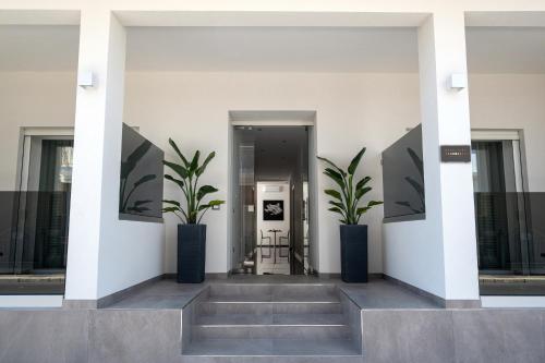un corridoio con due piante in vaso in un edificio di Moonlight B&B a Porto Cesareo