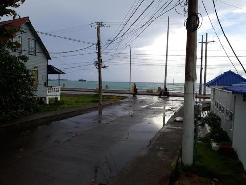 a person walking down a wet street next to the ocean at Posada Green Sea San Luis pesos with breakfast included starting in March in Cueva de Morgan