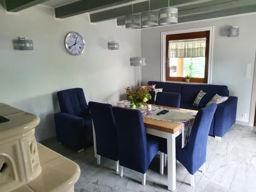 a dining room with a table and blue chairs at Domki Niesiołowice in Niesiołowice