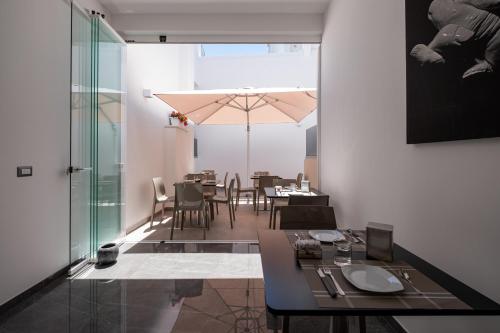 una sala da pranzo con tavolo, sedie e ombrellone di Moonlight B&B a Porto Cesareo
