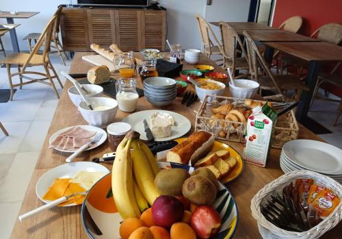 Hôtel Le Gois في بوفوار سور مير: طاولة خشبية مليئة بالكثير من الأطباق من الطعام