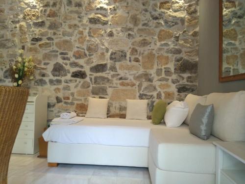 um sofá branco num quarto com uma parede de pedra em Valley View Lodge em Anópolis