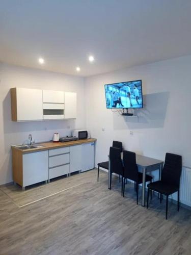 a room with a kitchen with a table and chairs at Apartament Po schodkach in Duszniki Zdrój
