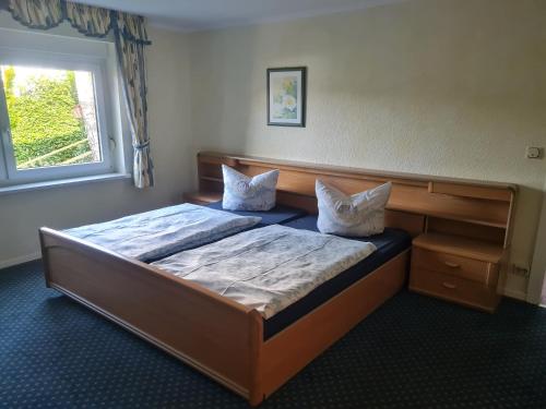 ein Schlafzimmer mit einem Bett mit zwei Kissen und einem Fenster in der Unterkunft Apartmenthaus Sonnenschein in Winterberg