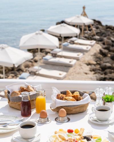 Ein Tisch mit Frühstücksspeisen in der Nähe des Meeres in der Unterkunft White Suites Resort in Afytos