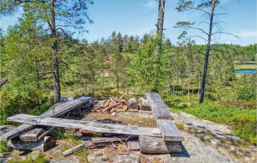a wooden bench sitting on top of a pile of wood at Cozy Home In Marnardal With Wifi in Marnardal