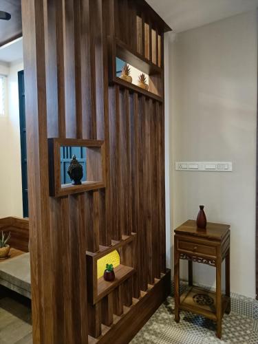 a room with a wooden wall with shelves and a table at Hotel ESSENCE in Vellore