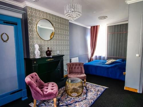 a bedroom with a bed and a chair and a mirror at Le Clos de la Chapelle Bayeux in Bayeux